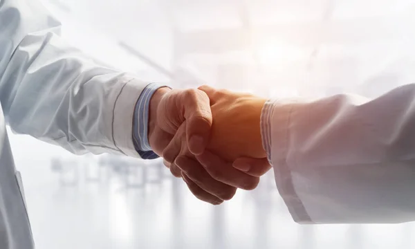 Close-up of the handshake between the two medics. Against the backdrop of the cityscape — Stock Photo, Image