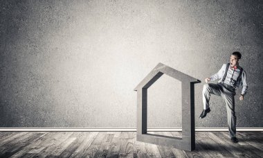 Taştan ev silueti, emlak sigortasının sembolü olarak boş odada.