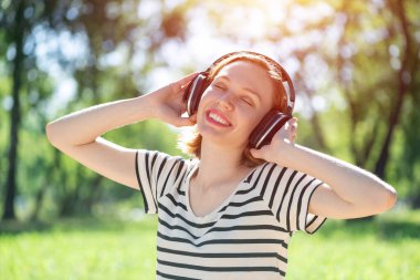 Bir yaz parkında müzik çalan genç bir kadın.