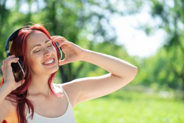 Bir yaz parkında müzik çalan genç bir kadın.