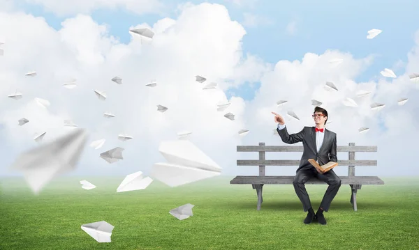 Giovane studente con un libro su una panchina — Foto Stock