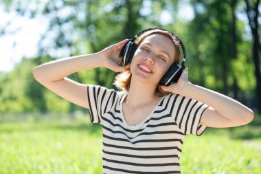 Bir yaz parkında müzik çalan genç bir kadın.