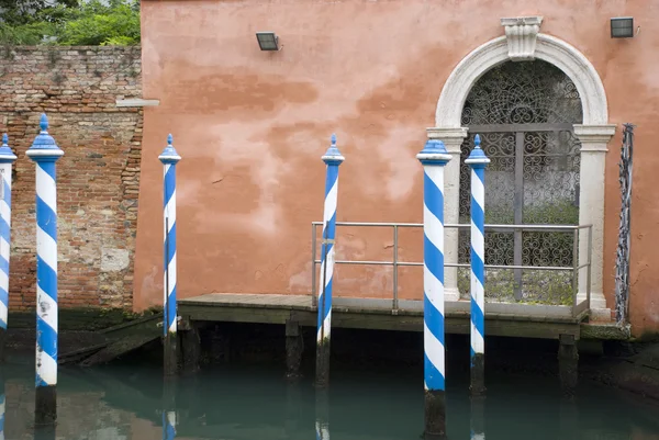 Terracotta house in venice with typical striped stakes in front — Stock Photo, Image