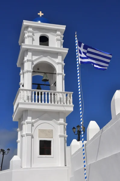 Pravoslavná církev věž s řeckou vlajku, santorini — Stock fotografie