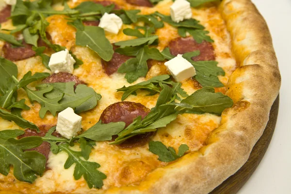 Pizza close-up on wooden plate isolated on white — Stock Photo, Image