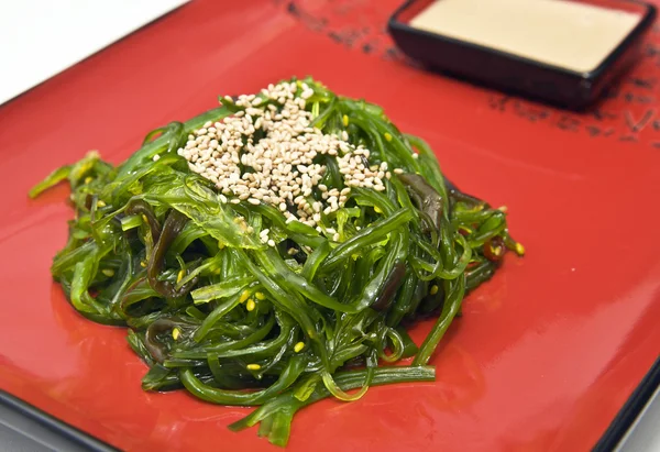 Wakame seaweed in peanut sauce with sesame seeds — Stock Photo, Image