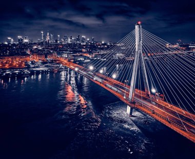 Güzel panoramik hava aracı gökyüzü manzaralı Varşova 'nın arka planında Swietokrzyski asma köprüsü var. Geceleri büyük şehrin ışıkları, Polonya..