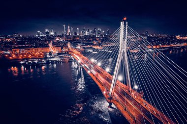 Güzel panoramik hava aracı gökyüzü manzaralı Varşova 'nın arka planında Swietokrzyski asma köprüsü var. Geceleri büyük şehrin ışıkları, Polonya..
