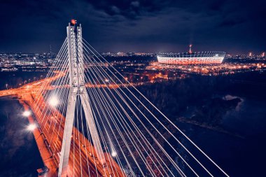 Güzel panoramik hava aracı gökyüzü manzaralı Varşova 'nın arka planında Swietokrzyski asma köprüsü var. Geceleri büyük şehrin ışıkları, Polonya..