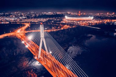 Güzel panoramik hava aracı gökyüzü manzaralı Varşova 'nın arka planında Swietokrzyski asma köprüsü var. Geceleri büyük şehrin ışıkları, Polonya..