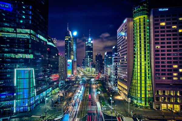 Beautiful panoramic aerial drone skyline view of the center of night Warsaw with skyscrapers in the background on avenues of John Paul II - the lights of the big city by night, Poland, EU.