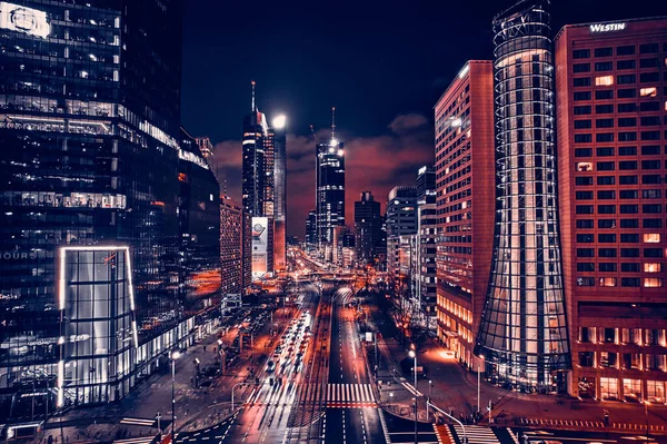 Beautiful panoramic aerial drone skyline view of the center of night Warsaw with skyscrapers in the background on avenues of John Paul II - the lights of the big city by night, Poland, EU.