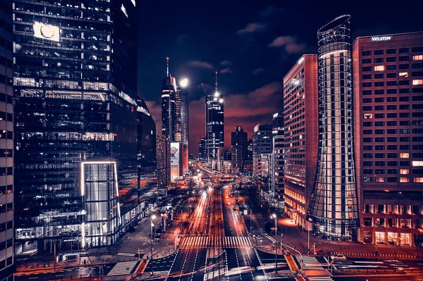 Beautiful panoramic aerial drone skyline view of the center of night Warsaw with skyscrapers in the background on avenues of John Paul II - the lights of the big city by night, Poland, EU.
