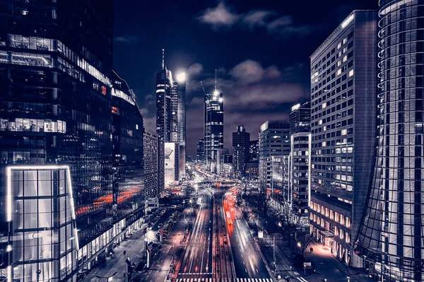 Beautiful panoramic aerial drone skyline view of the center of night Warsaw with skyscrapers in the background on avenues of John Paul II - the lights of the big city by night, Poland, EU.