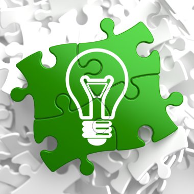 Light Bulb Icon on Green Puzzle. clipart