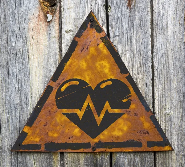 Corazón con línea de cardiograma en señal de advertencia . — Foto de Stock