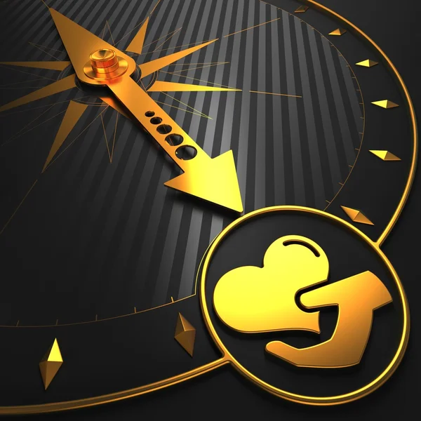 Goldene Ikone des Herzens in der Hand am Kompass. — Stockfoto