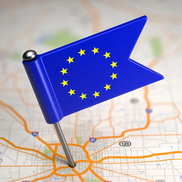 De kleine vlag van de Europese Unie op de achtergrond van een kaart. — Stockfoto