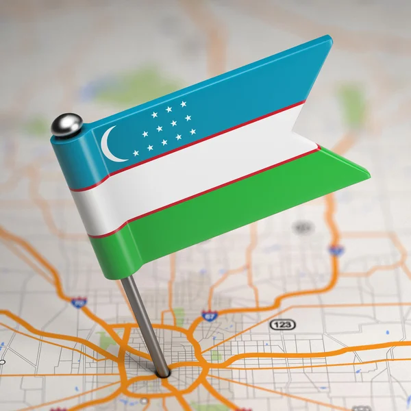 Mała flaga Uzbekistanu na tle mapy. — Zdjęcie stockowe