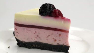 Beyaz seramik tabakta lezzetli ev yapımı ahudududulu cheesecake. Bir porsiyon donmuş ahududu peynirli kek. Beyaz tabakta korunmuş ahududu ile süslenmiş..