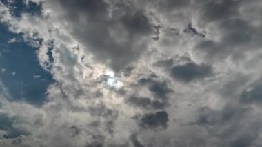 Güneş gökyüzündeki bulutların arkasında hareket ediyor. Yağmur mevsiminde bulutlu hava. Gündüz vakti tropik güneş. Kara yağmur bulutları geliyor..