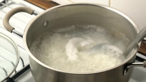 料理を閉じ 沸騰泡と金属鍋に鍋で鍋でゆで卵ご飯を攪拌 — ストック動画