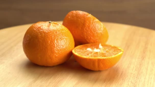 木製の回転板に回転する熟したオレンジの全体と2つの半分の側面図 — ストック動画