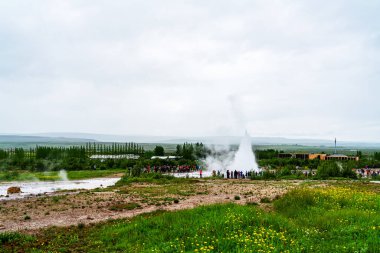 Haukadalur, İzlanda - 4 Temmuz 2018: Strokkur gayzer ve İzlanda 'nın güneybatısındaki Haukadalur vadisi jeotermal bölgesinde turist ziyaretçileri.
