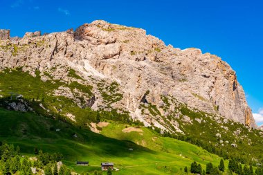Langkofel grubunun doğal manzarası veya İtalyan Dolomitleri 'ndeki yeşil tepe ve kırmızı gondollu Sassolungo grubu veya İtalya' nın Güney Tyrol kentindeki Gardena Geçidi 'ndeki kırmızı teleferik..