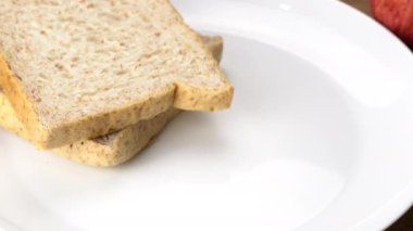 Chef man putting a bowl of delicious hot beef stew in white ceramic bowl on white plate with sloce of wholw wheat bread.
