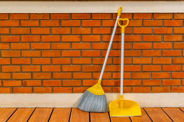 Long Handle Plastic Yellow Broom Dustpan Prop Red Brick Wall Obrazy Stockowe bez tantiem