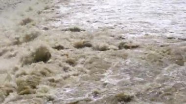 Çamurlu su nehirde hızla akıyor. Çamurlu sularda yüzmek, akmak, tayfundan sonra kirli bir nehirde su sıçratmak..