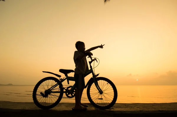 Silhouette eines kleinen Jungen mit Fahrrad — Stockfoto