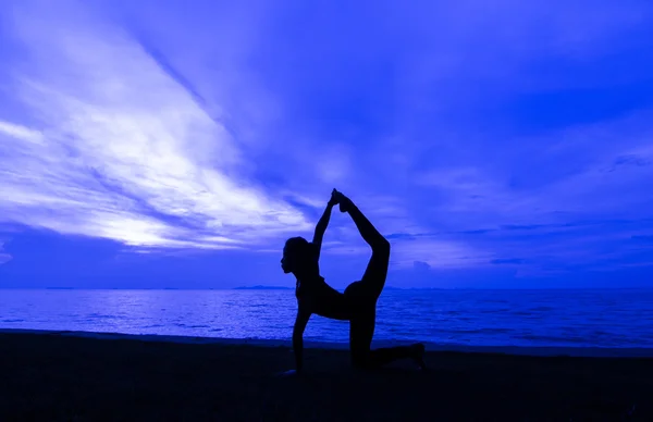 Yoga posure kadınla siluet — Stok fotoğraf