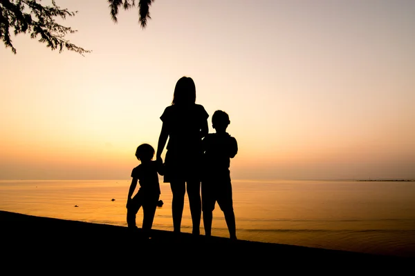 Silhuett av familjen på stranden — Stockfoto