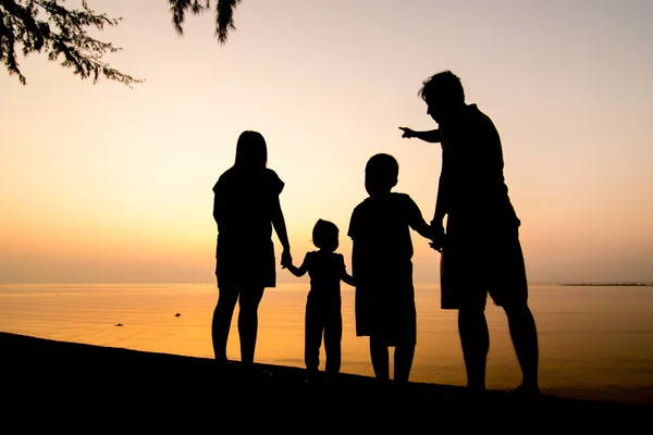 Silhuett av familjen på stranden — Stockfoto