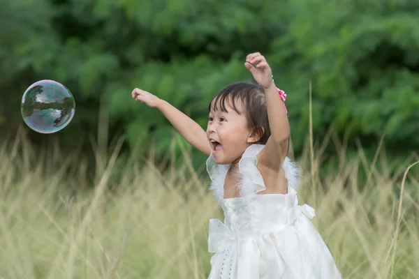 Kind spielt mit Seifenblasen. — Stockfoto