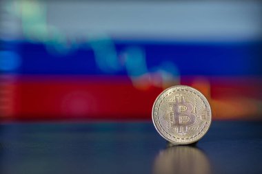 Rus bayrağının arka planında Bitcoin madeni para ve bir düşüş grafiği