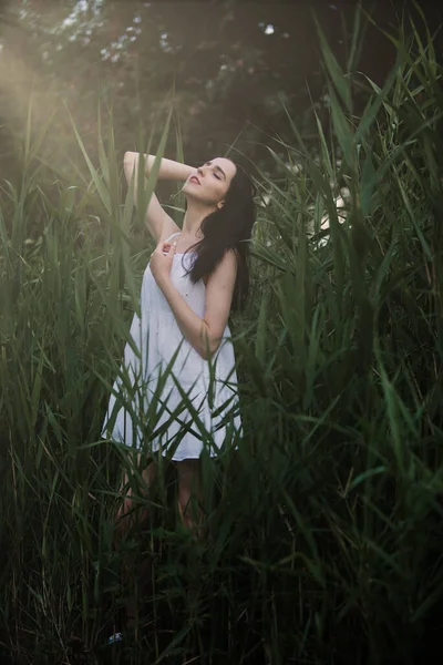 Doğada, nehrin kenarında kısa beyaz elbiseli güzel seksi kız. — Stok fotoğraf