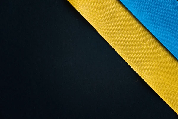 Siyah arka planda Ukrayna bayrağı. mavi ve sarı kurdeleler.