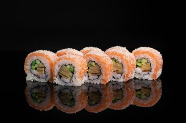 Siyah parlak arka planda suşi rulosu.