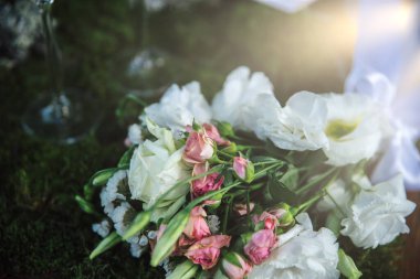 Arka planda yeşil bulanık arka planda düğün buketi ve gözlük var..