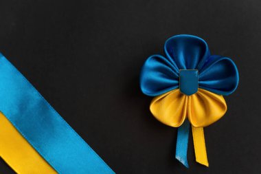 Ukrayna bayrağı çiçeği Ukrayna arması ile siyah bir arka planda kurdelelerden