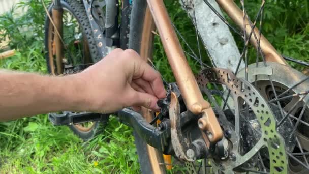 男は背景がぼやけた公園で自転車を修理する 高品質4K映像 — ストック動画