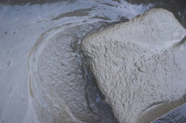 Bir usta tarafından konteynırda çimento karıştırılması. Yüksek kalite fotoğraf