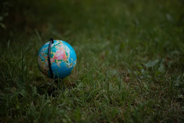 Globe on green grass on a summer cloudy day. High quality photo