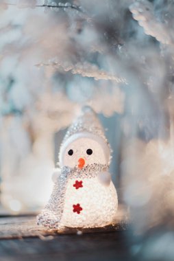 Küçük beyaz kardan adam - Ahşap arka planda Noel ağacı süsleme oyuncağı.