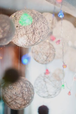 Beyaz Noel topları arka planda bulanık, çelenkler ise bokeh efektli..