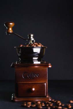 Kahve öğütücüsü, siyah arkaplanda kahve çekirdekleri..