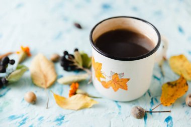 Sonbahar hala hayattır. Bir fincan çay ve arka planda sarı sonbahar yaprakları..